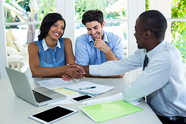 happy-couple-shaking-hands-with-real-estate-agent-ENP3UQ9